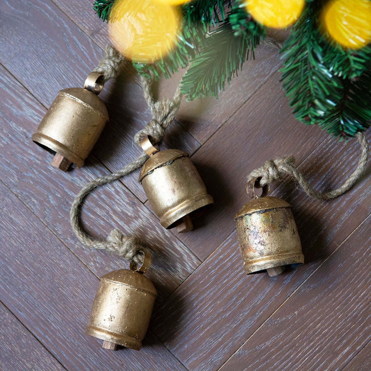 Four recycled iron vintage-style bells hanging on natural rope